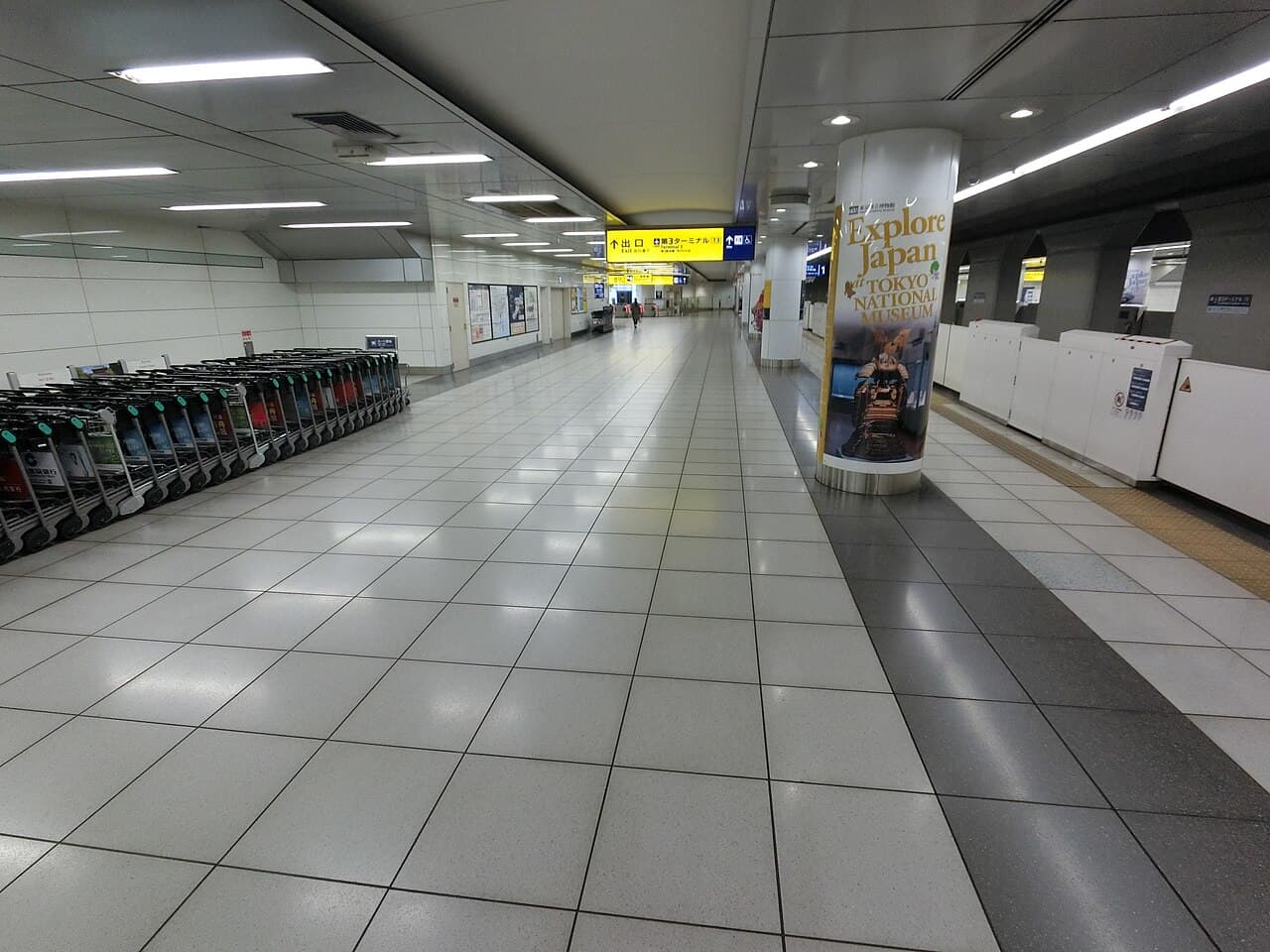 Platform area at Haneda Airport Terminal 3 with a yellow terminal exit sign.