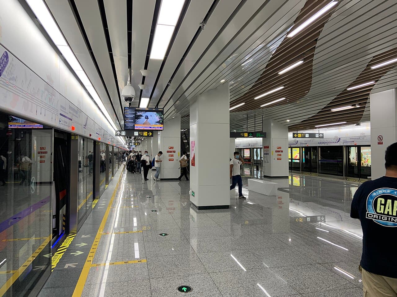 Metro platform with screen doors and passengers at Tianfu Airport Terminal 1&2 station.