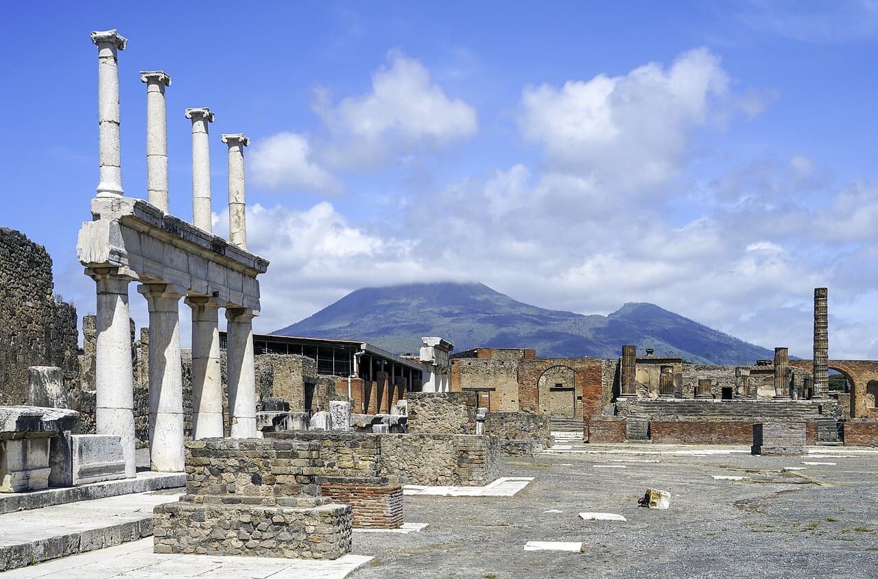 The forum at Pompeii, with ancient columns in the foreground and Vesuvius beyond.