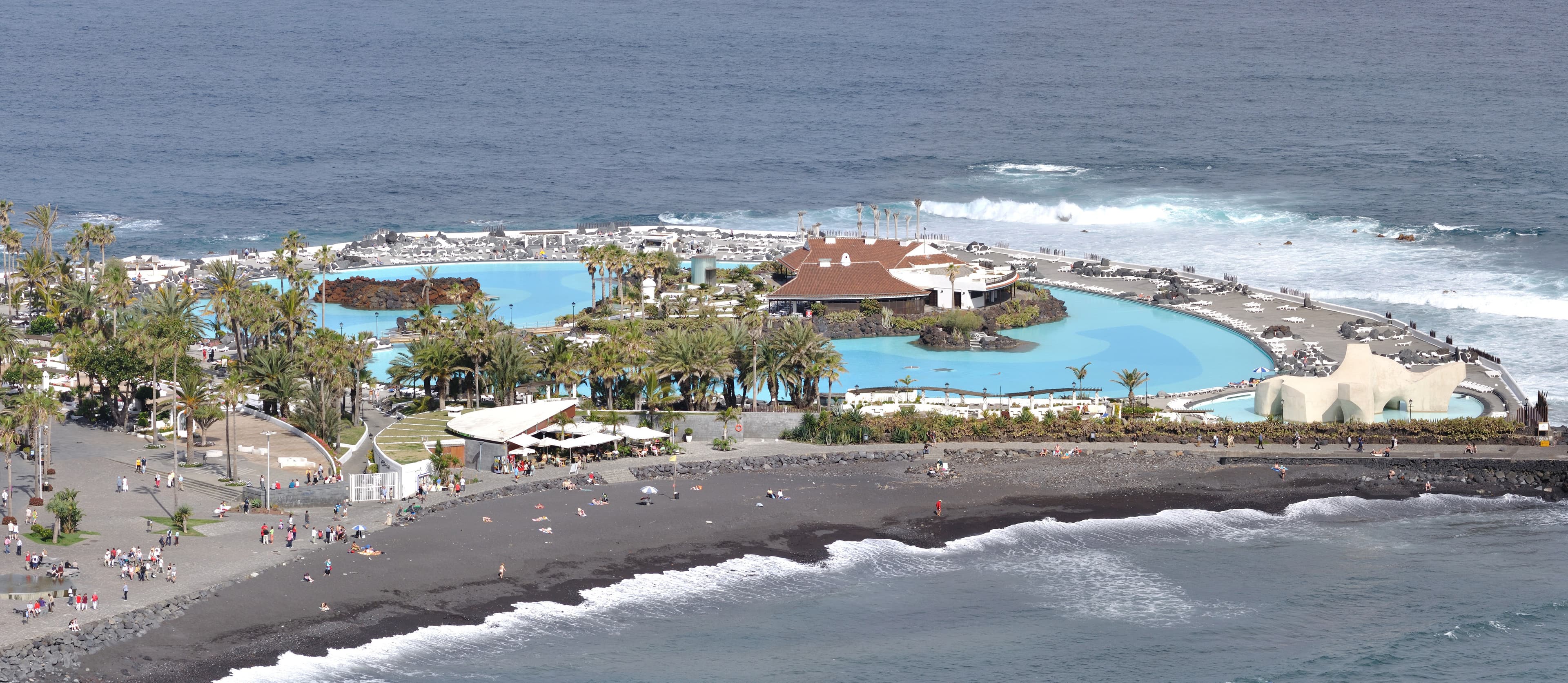 Turquoise pools of Lago Martiánez, palm trees and the Atlantic coast in Puerto de la Cruz.