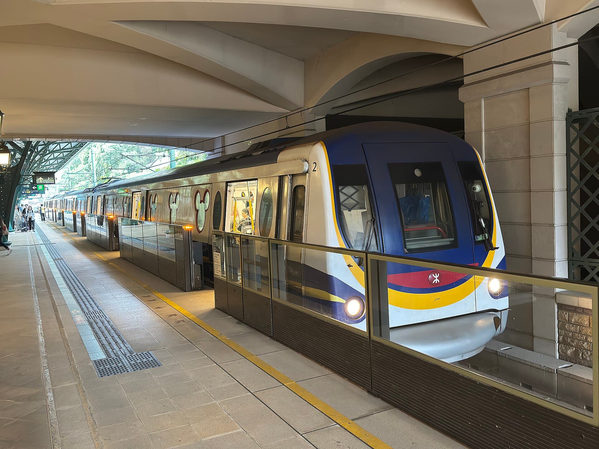 Disneyland Resort Line train with Mickey-shaped windows beside the platform in Hong Kong.