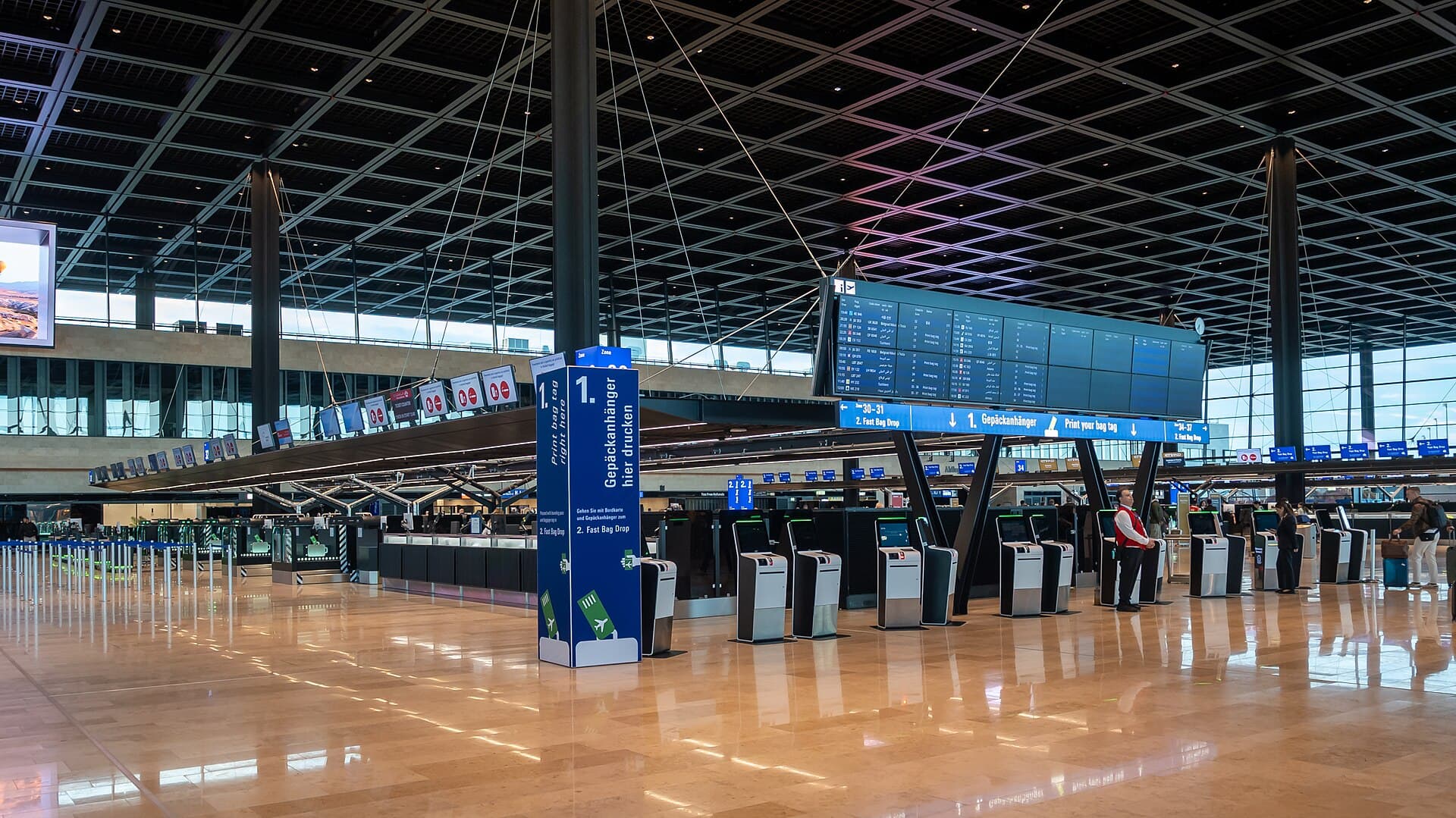 Departure information board and self-service check-in machines in Frankfurt Airport Terminal 3.