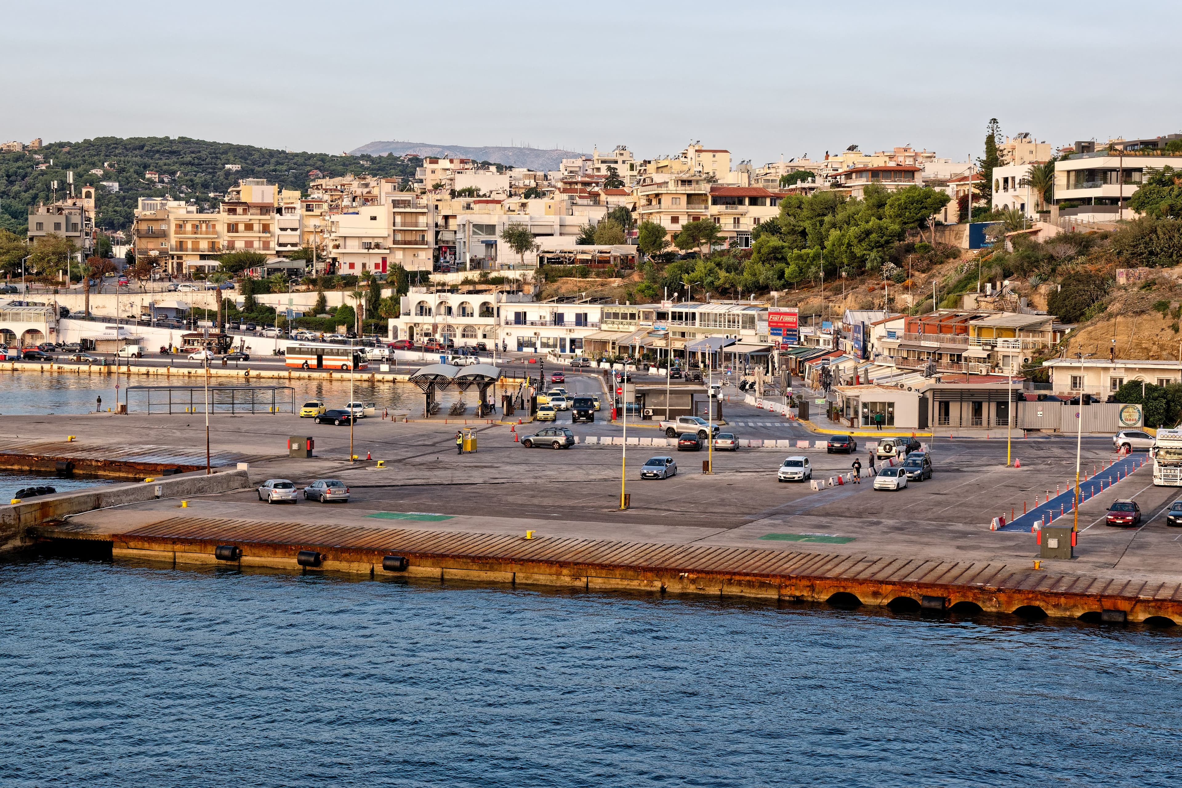 Rafina harbour quayside with cars, a bus and the town behind