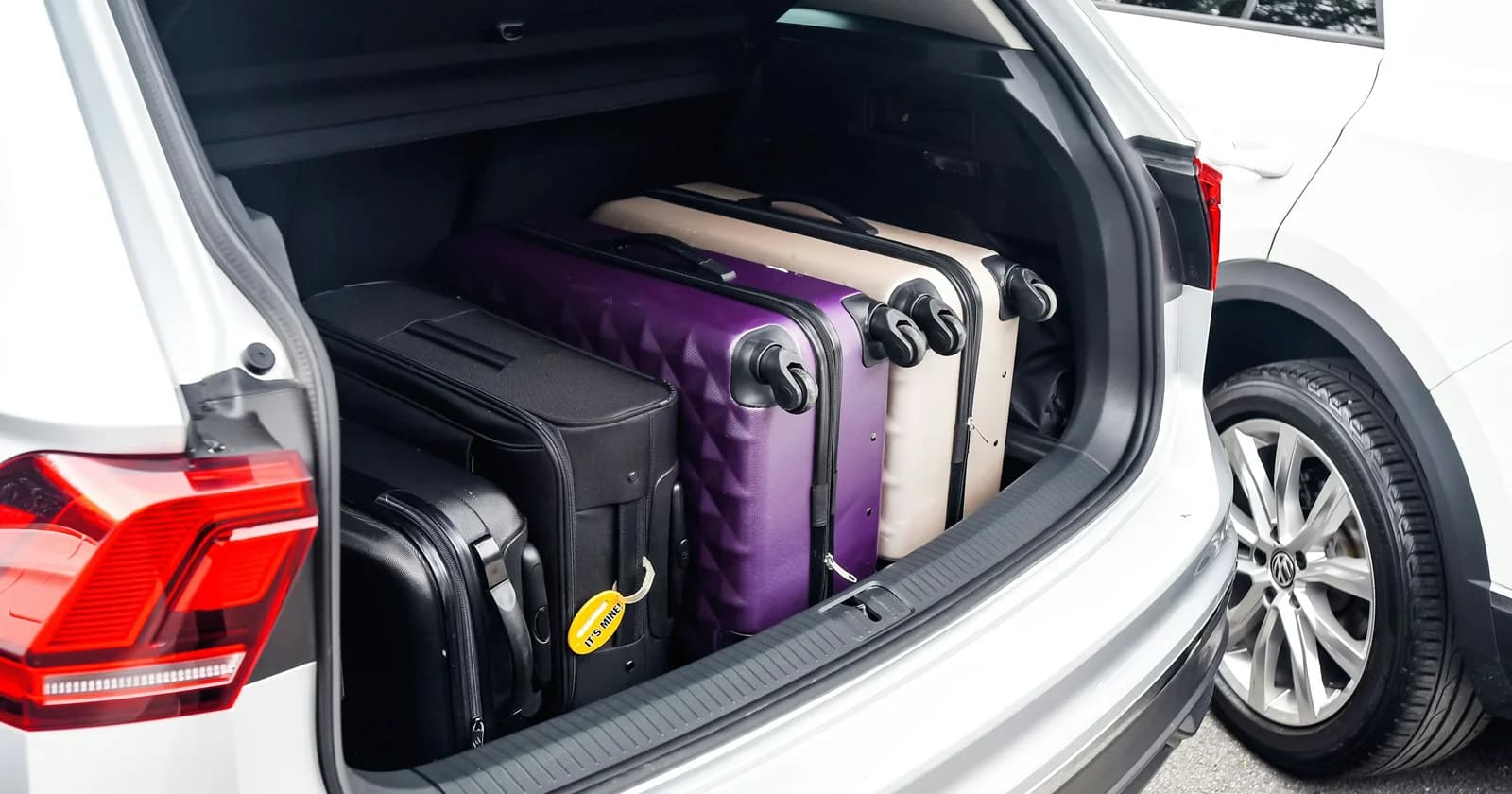 Suitcases packed into the open boot of a Volkswagen SUV