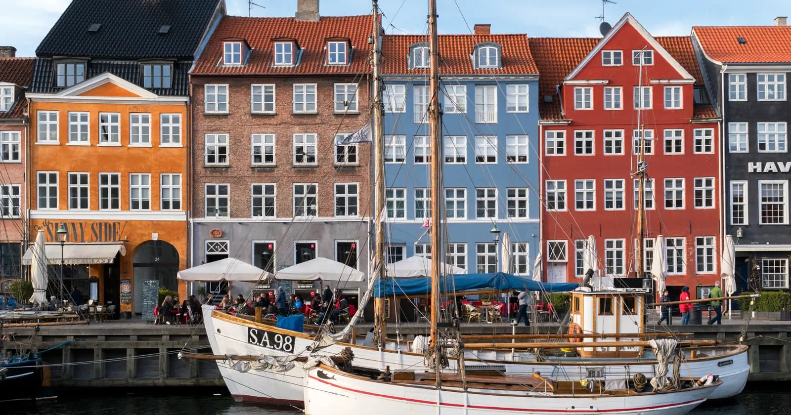 Colourful waterfront buildings and a boat on Nyhavn in Copenhagen