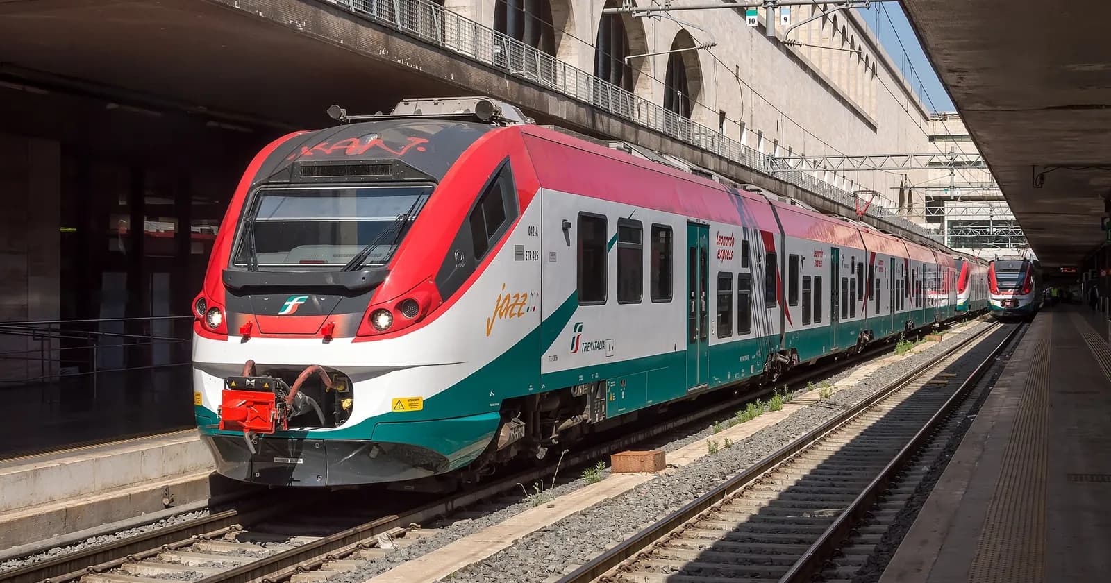 A red, white and green Leonardo Express train at Roma Termini